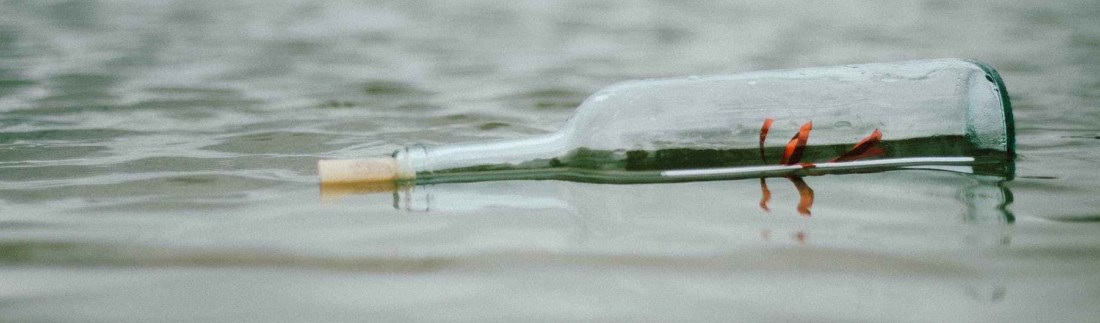 selective focus photo of bottle floating on body of water